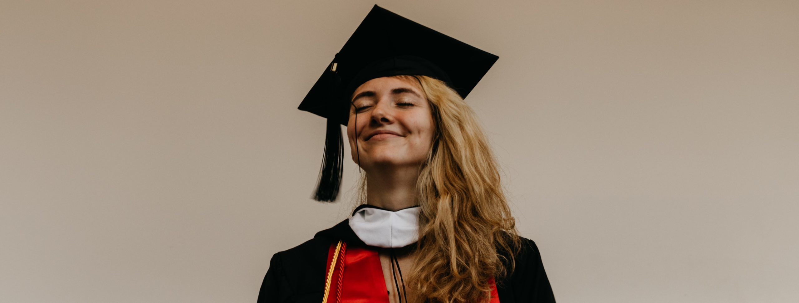 smiling woman in graduation gown and cap