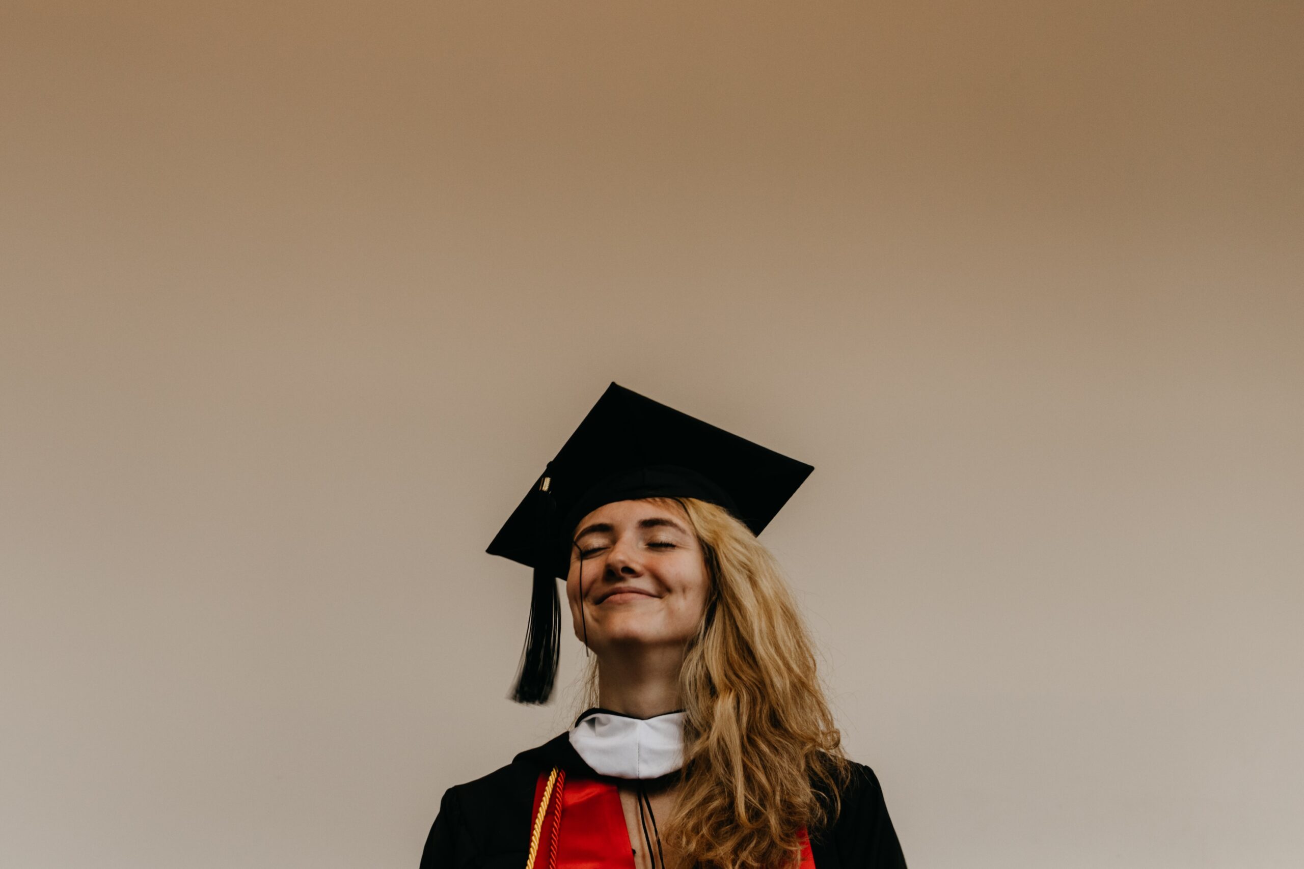 smiling woman in graduation gown and cap