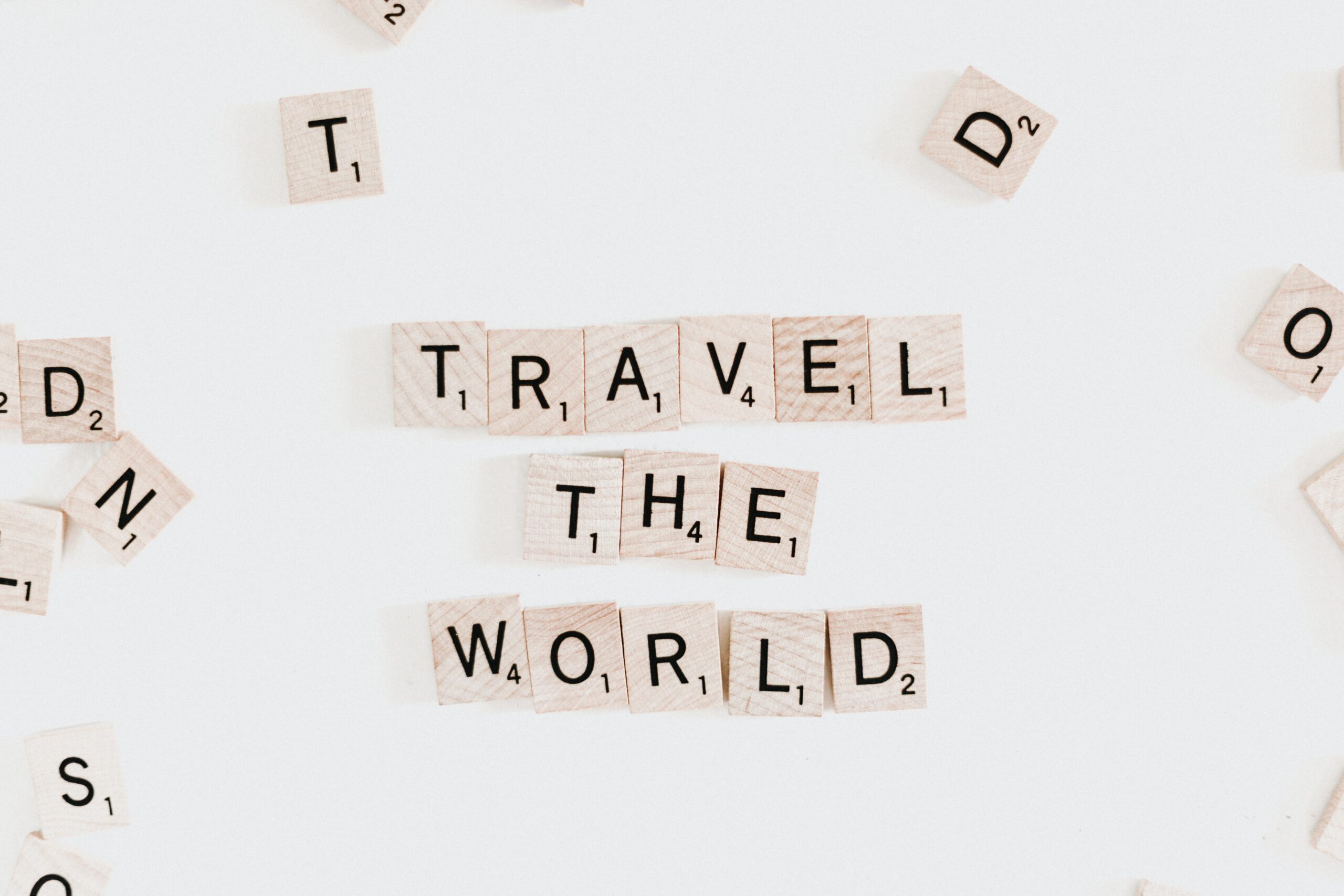 scrabble tiles spelling out travel the world