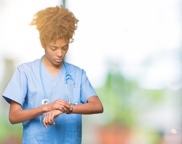 Young african american nursechecking the time on wrist watch