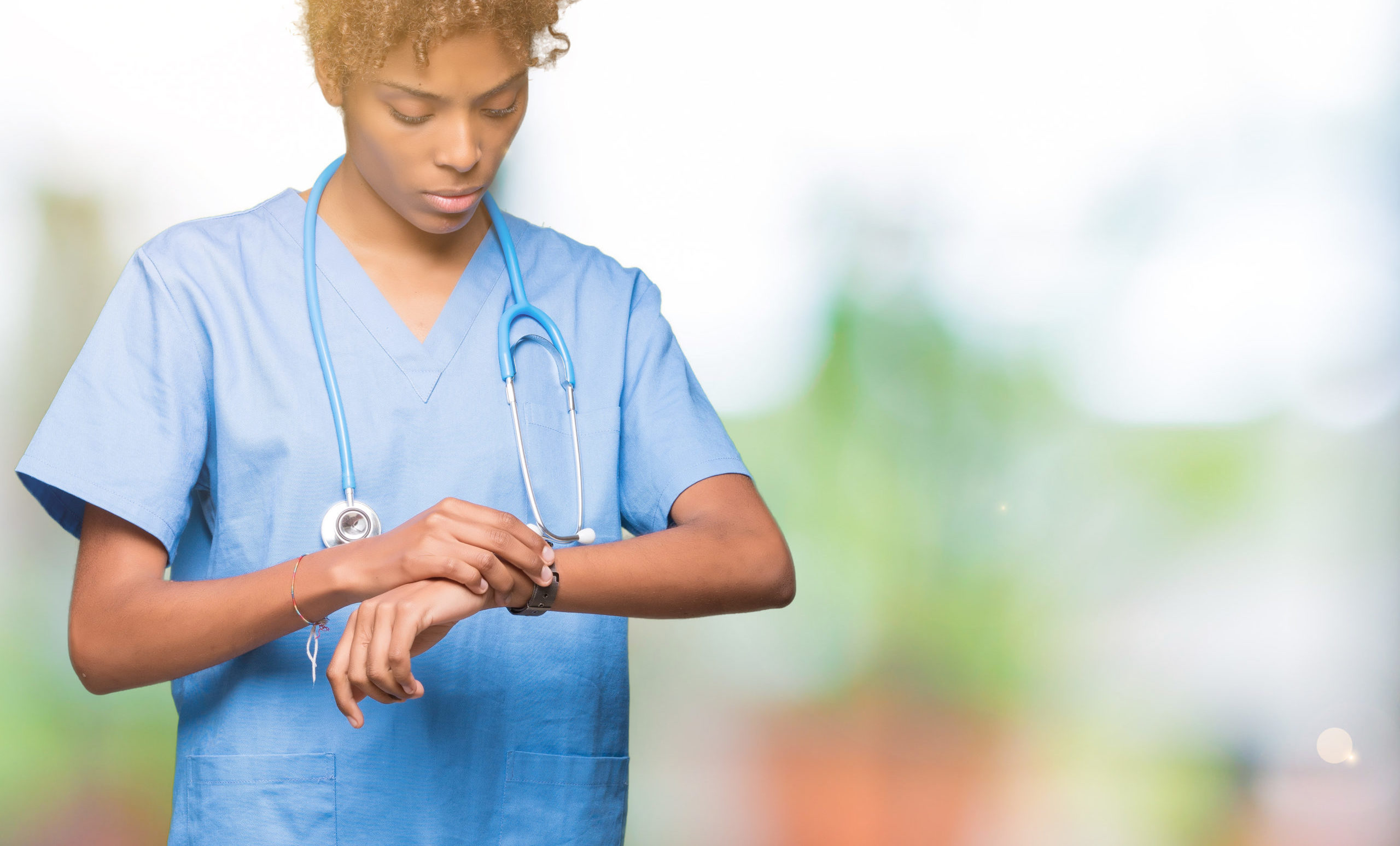 Young african american nursechecking the time on wrist watch