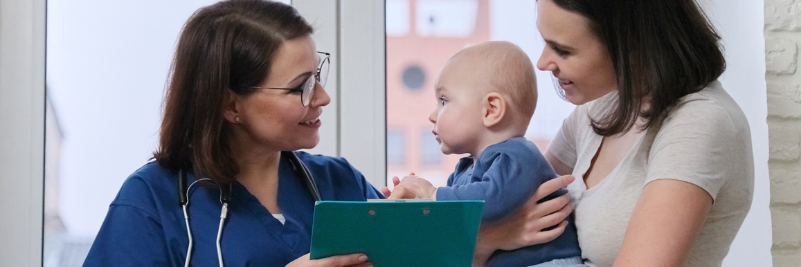 Friendly nurse smiling to baby patient