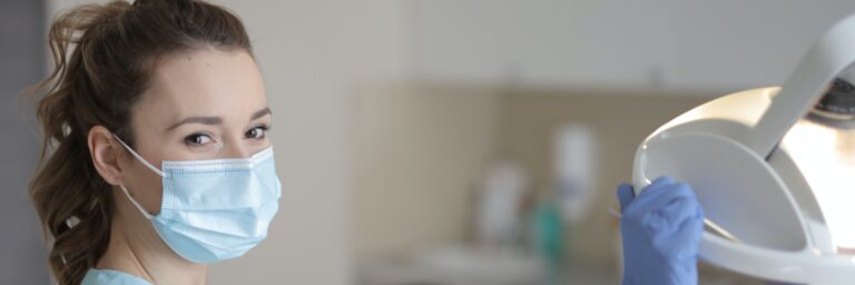 Young female nurse in mask and gloves