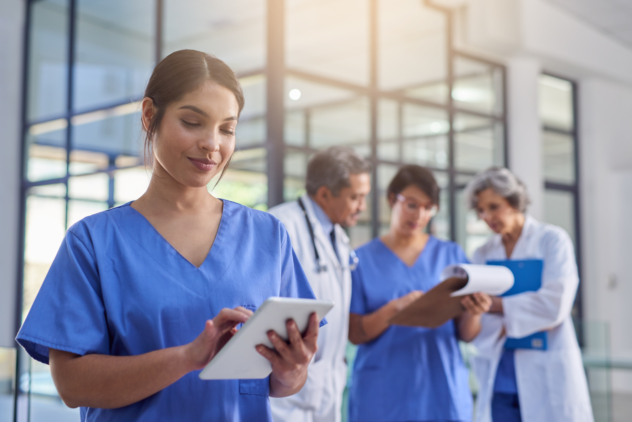 Nurse looking at tablet smiling