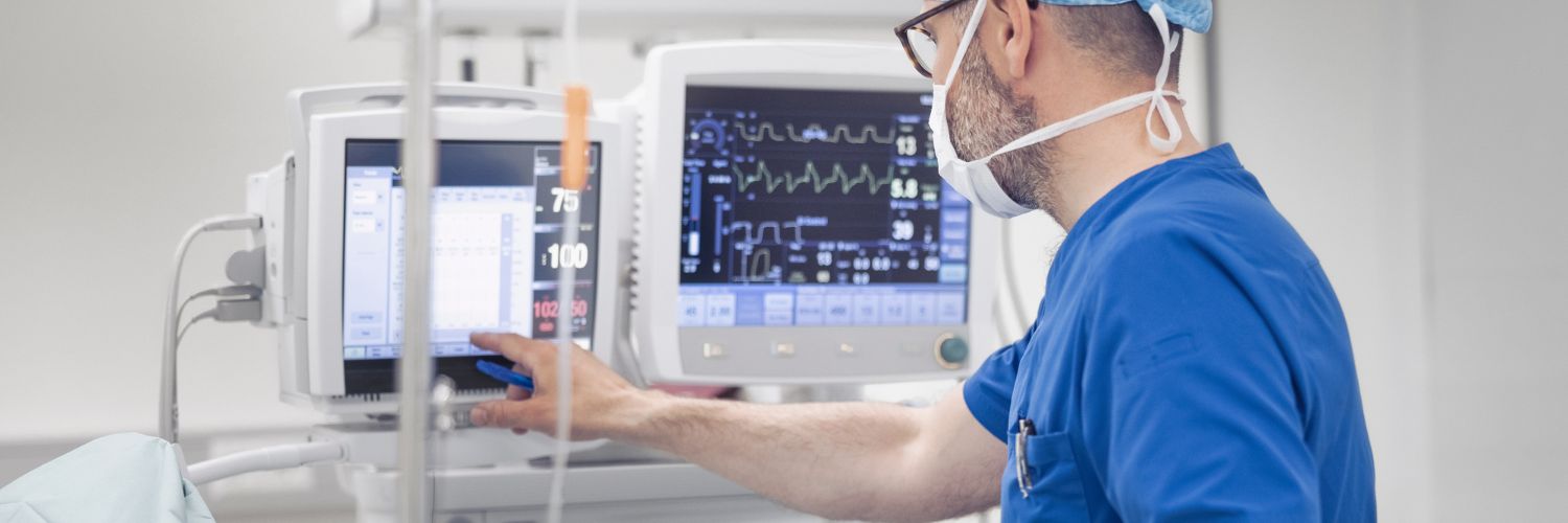 A surgical technologist reads medical information on a screen