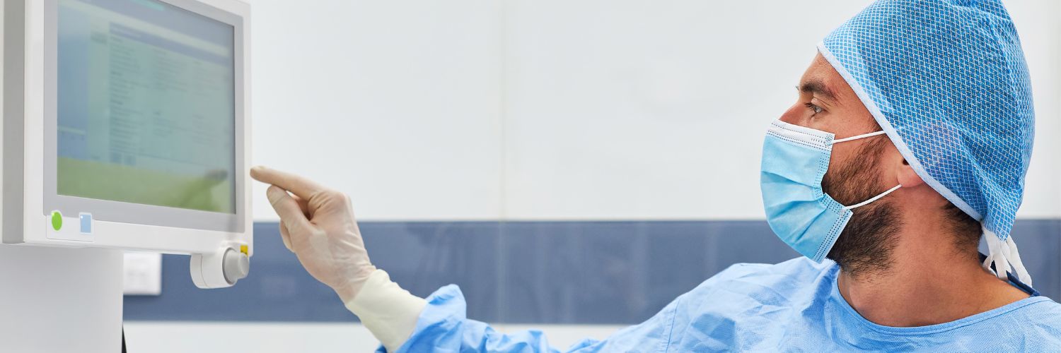 A surgical tech assesses medical information on a screen